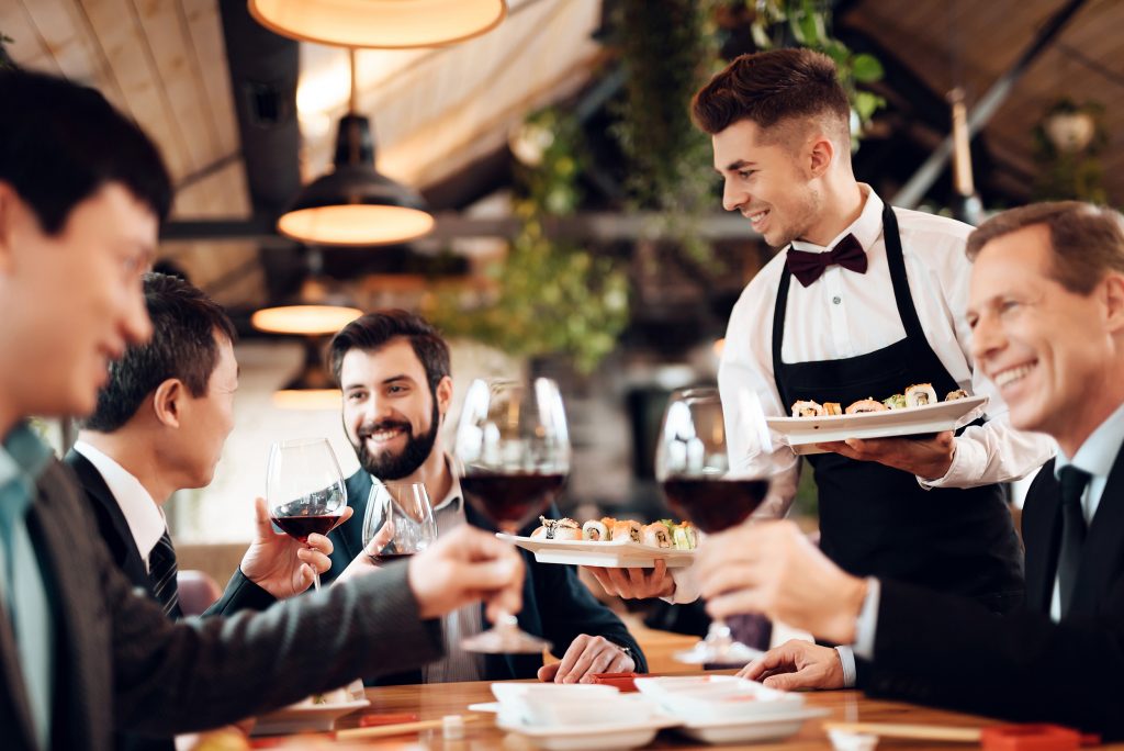 a man carrying plates in a restaurant as one of the business ideas for expats in Dubai