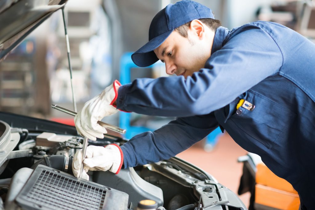 Auto mechanic working on a car in his garage