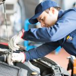 Auto mechanic working on a car in his garage