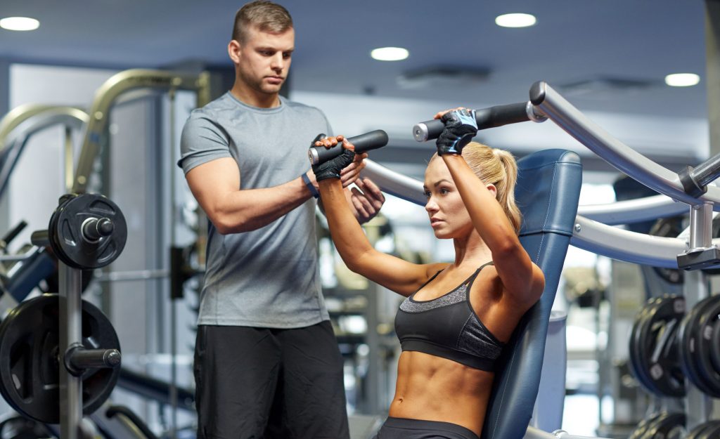 A personal trainer helping a women exercise